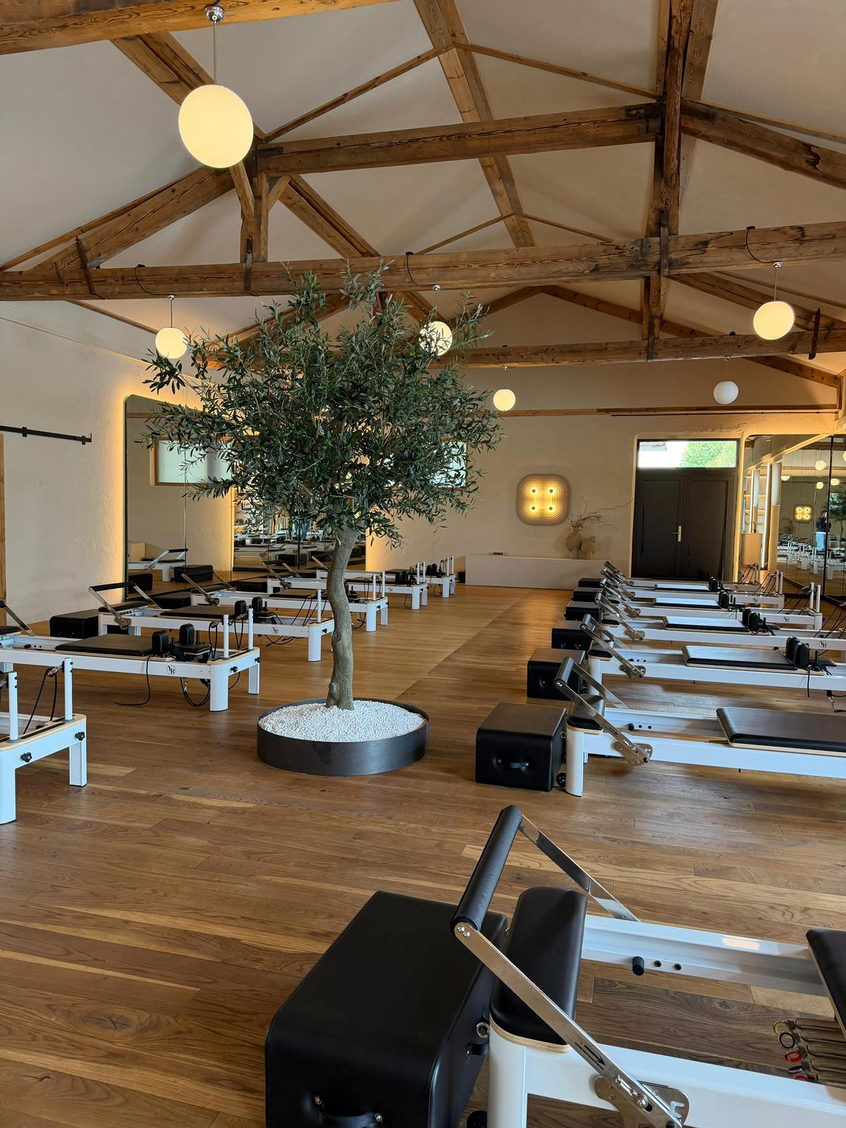 MAIKAI NALU Reformer Pilates Studio – warmes Holz, Olivenbaum, weiche Lichtkugeln